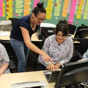 teacher pointing at a computer