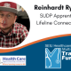 White and blue background. Circular photo on the left of Reinhardt, a white man wearing a red hat and shirt with facial piercings. Black text on the right reads "Reinhardt Ryden, SUDP Apprentice, Lifeline Connections". Training Fund and Healthcare Apprenticeship Consortium logos on the bottom.