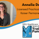 Orange and white background split by light blue waved line. Upper half circular photo of a white woman wearing a sweater and stethoscope. Black text "Annelie Day, Licensed Practical Nurse, Kaiser Permanente. Bottom half Training Fund logo on white background.